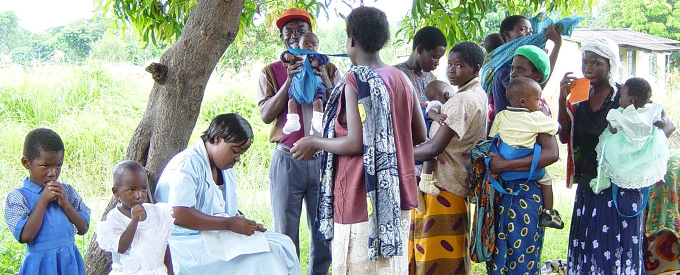 Women under tree with other family members